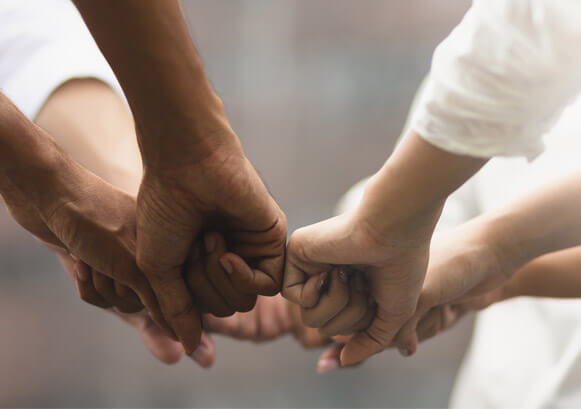 Multiple people doing fist bump at the same time 