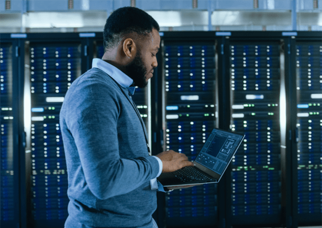Man on laptop in datacenter
