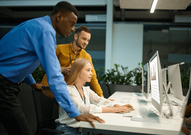 People collaborating around a desktop computer