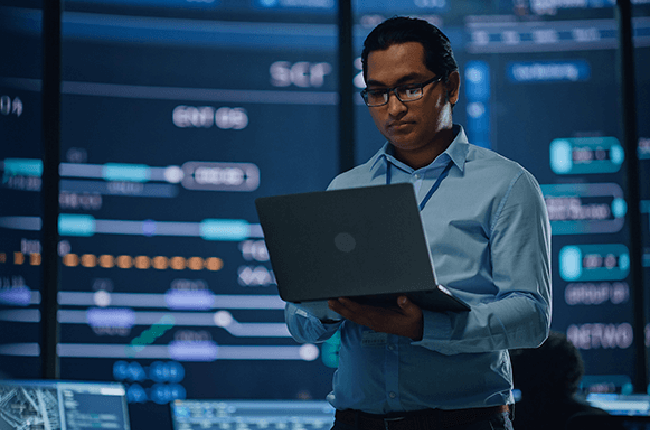Man on laptop in data center