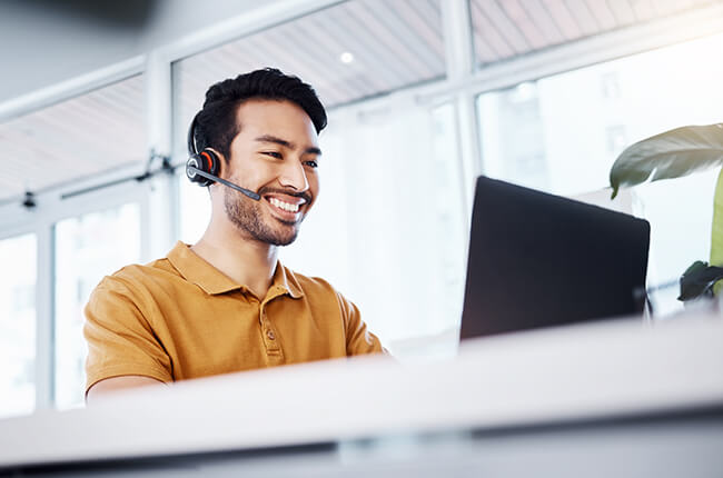 Man on laptop with headset