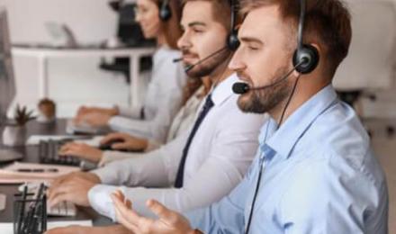 Many agents with headsets at screens